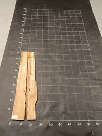 Planche bois d'olivier rabotée 2 cm à bord naturel, 140×30 cm, réf P34, sur tapis quadrillé 10 cm — verso
