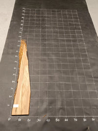 Planche bois d'olivier rabotée 2 cm à bord naturel, 175×25 cm, réf P36, sur tapis quadrillé 10 cm — verso