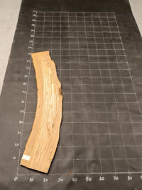 Planche bois d'olivier rabotée 2 cm à bord naturel, 175×28 cm, réf P19, sur tapis quadrillé 10 cm — recto