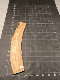 Planche bois d'olivier rabotée 2 cm à bord naturel, 175×28 cm, réf P19, sur tapis quadrillé 10 cm — verso