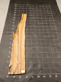 Planche bois d'olivier rabotée 2 cm à bord naturel, 175×30 cm, réf P13, sur tapis quadrillé 10 cm — verso