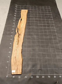 Planche bois d'olivier rabotée 2 cm à bord naturel, 175×32 cm, réf P31, sur tapis quadrillé 10 cm — verso