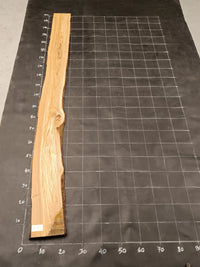 Planche bois d'olivier rabotée 2 cm à bord naturel, 180×25 cm, réf P17, sur tapis quadrillé 10 cm — verso