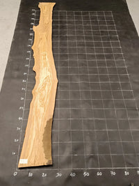 Planche bois d'olivier rabotée 2 cm à bord naturel, 185×25 cm, réf P15, sur tapis quadrillé 10 cm — verso
