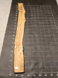 Planche bois d'olivier rabotée 2 cm à bord naturel, 185×28 cm, réf P04, sur tapis quadrillé 10 cm — verso