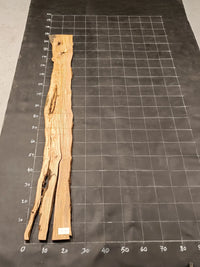 Planche bois d'olivier rabotée 2 cm à bord naturel, 185×28 cm, réf P14, sur tapis quadrillé 10 cm — verso