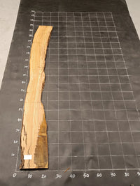 Planche bois d'olivier rabotée 2 cm à bord naturel, 185×30 cm, réf P20, sur tapis quadrillé 10 cm — verso