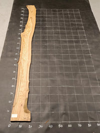 Planche bois d'olivier rabotée 2 cm à bord naturel, 185×30 cm, réf P26, sur tapis quadrillé 10 cm — verso