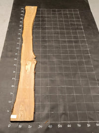 Planche bois d'olivier rabotée 2 cm à bord naturel, 185×30 cm, réf P28, sur tapis quadrillé 10 cm — recto