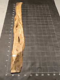 Planche bois d'olivier rabotée 2 cm à bord naturel, 185×35 cm, réf P16, sur tapis quadrillé 10 cm — verso