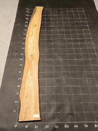 Planche bois d'olivier rabotée 2 cm à bord naturel, 190×30 cm, réf P06, sur tapis quadrillé 10 cm — verso
