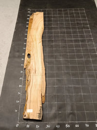 Planche bois d'olivier rabotée 2 cm à bord naturel, 190×32 cm, réf P12, sur tapis quadrillé 10 cm — verso