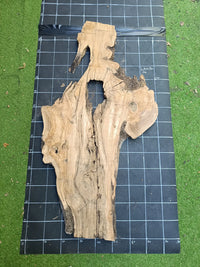 Plateau bois d'olivier brut à bord vivant 140×60 cm, réf N°003, sur tapis quadrillé 10 cm — verso