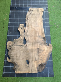 Plateau bois d'olivier brut à bord vivant 140×80 cm, réf N°004, sur tapis quadrillé 10 cm — verso
