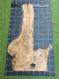 Plateau bois d'olivier brut à bord vivant 140×70 cm, réf N°005, sur tapis quadrillé 10 cm — recto