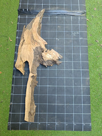 Plateau bois d'olivier brut à bord vivant 140×30 cm, réf N°009, sur tapis quadrillé 10 cm — recto