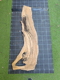 Plateau bois d'olivier brut à bord vivant 150×40 cm, réf N°026, sur tapis quadrillé 10 cm — verso
