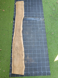 Plateau bois d'olivier brut à bord vivant 200×30 cm, réf N°027, sur tapis quadrillé 10 cm — verso