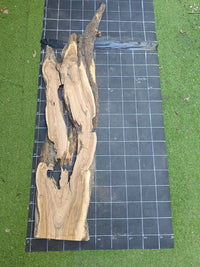 Plateau bois d'olivier brut à bord vivant 150×40 cm, réf N°028, sur tapis quadrillé 10 cm — recto