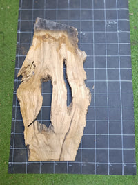 Plateau bois d'olivier brut à bord vivant 110×60 cm, réf N°041, sur tapis quadrillé 10 cm — verso