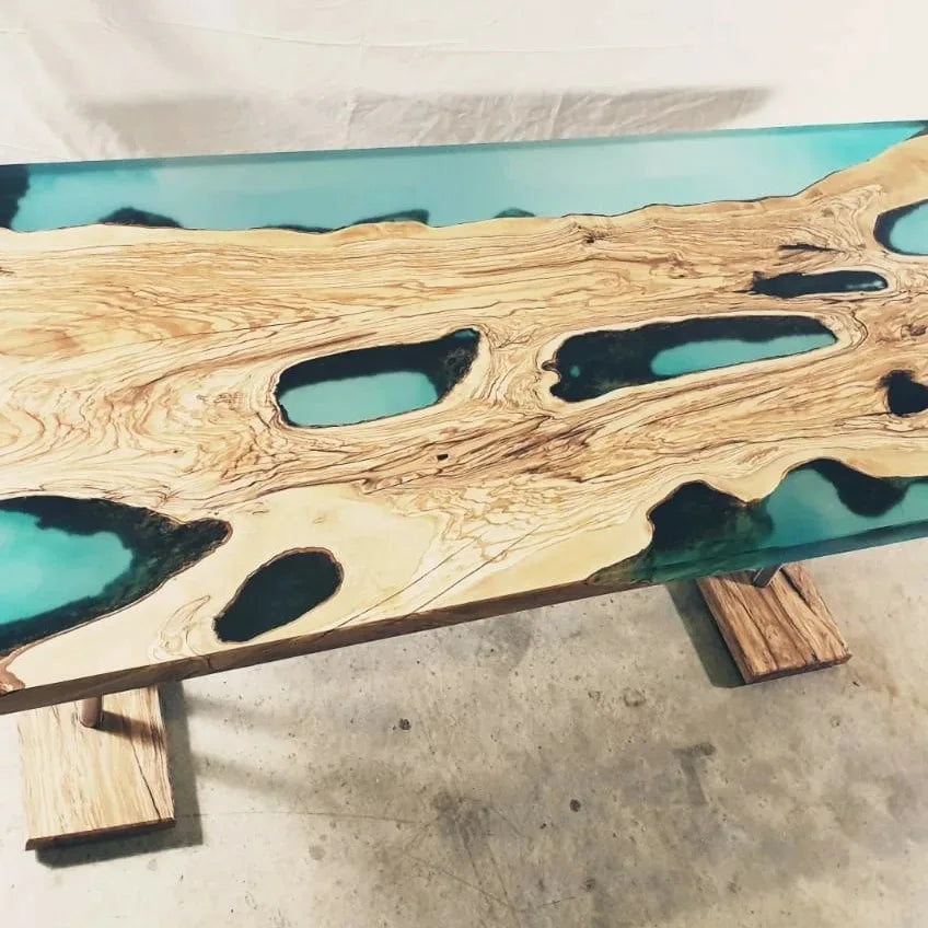 Table rivière en résine turquoise réalisée avec un plateau d'olivier