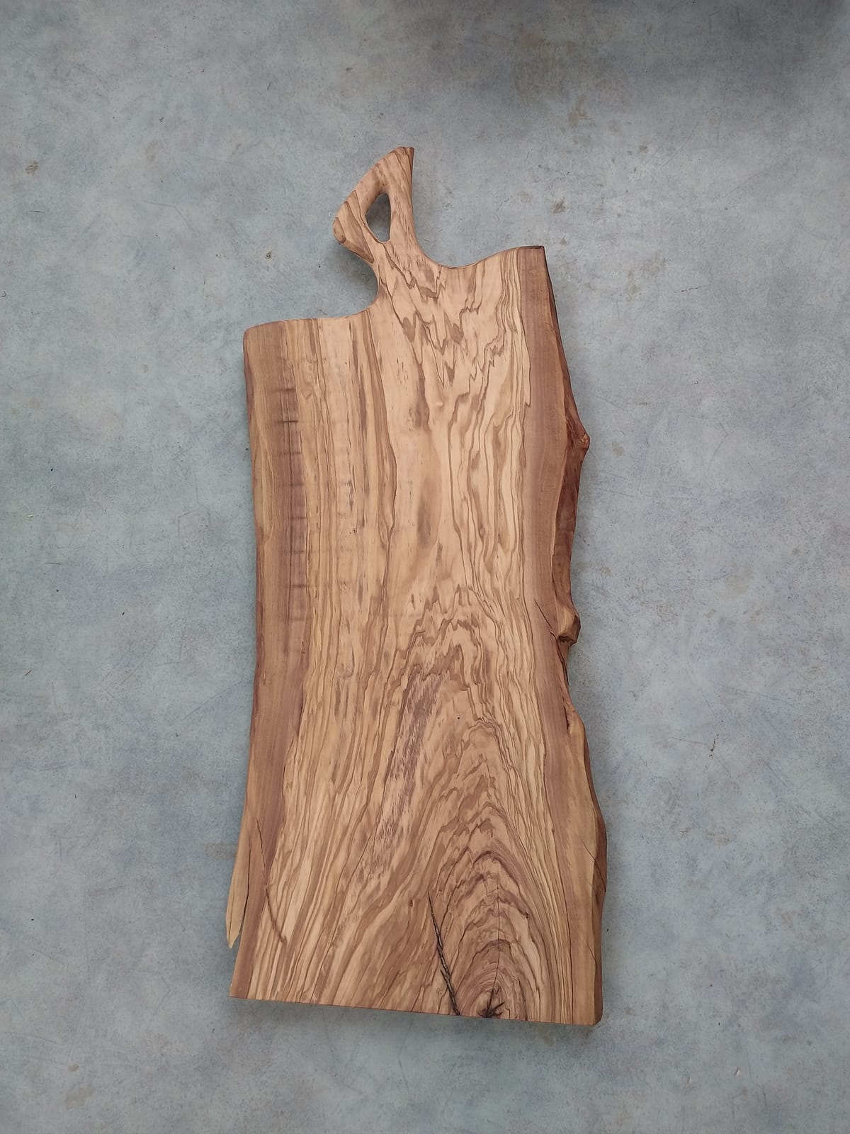 Planche à découper en bois d’olivier à bord naturel, poignée sculptée